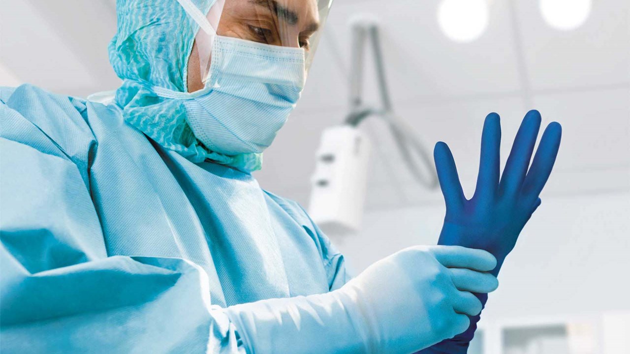 Surgeon using Biogel gloves with puncture indication