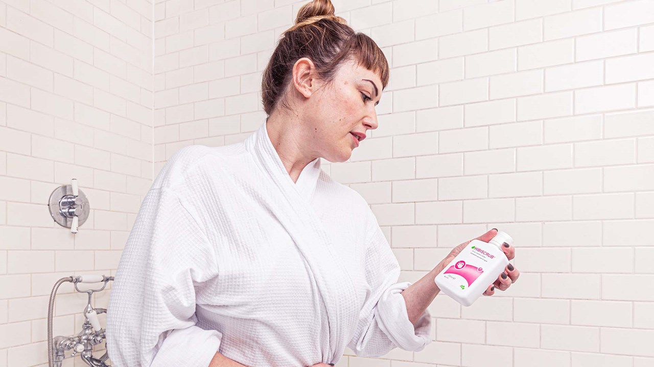 lady in shower using hibiscrub